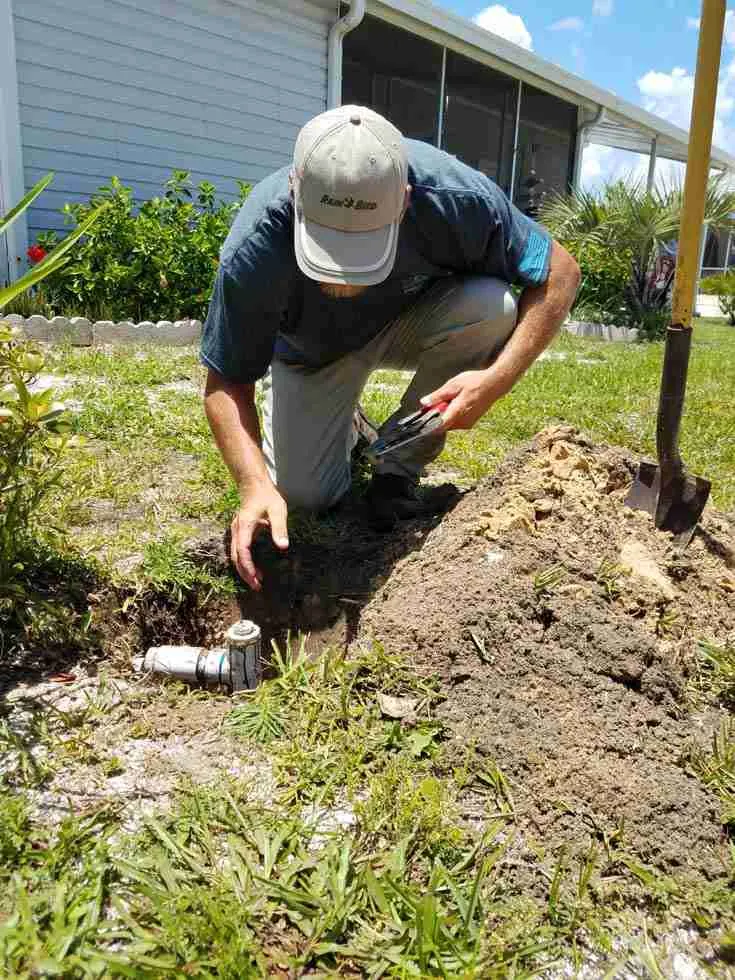 WaterCare crew excavating and repairing an irrigation valve box on a residential property